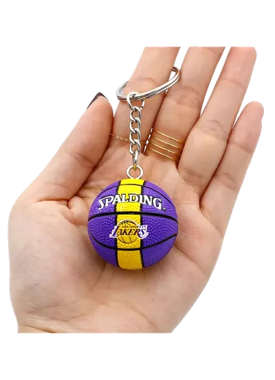 Portachiavi PVC 3D a forma di pallone da basket viola e giallo, tenuto in mano per mostrarne le dimensioni