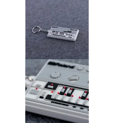 Portachiavi PVC 2D a forma di drum machine grigia, con i tasti stampati e un dettaglio ingrandito