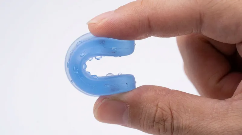 Portachiavi in PVC morbido senza ftalati piegato tra due dita, flessibile e impermeabile